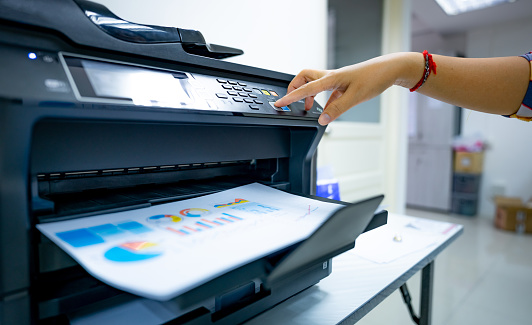 Office worker prints paper on multifunction laser printer